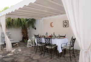 een witte tafel en stoelen onder een witte paraplu bij Casa delle sirene in Letojanni +41 foto's