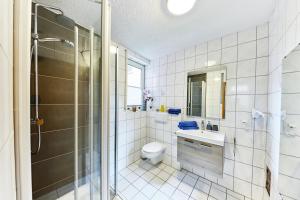 a bathroom with a shower and a toilet and a sink at Wohnung 21 - Erholung - nur 5 Minuten vom Europa-Park in Kappel-Grafenhausen +10 photos