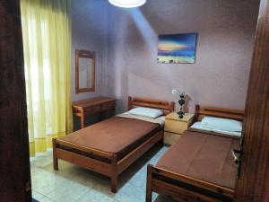 1 dormitorio con 2 camas y espejo en APARTMENTS HARIS, en Olympiakí Aktí