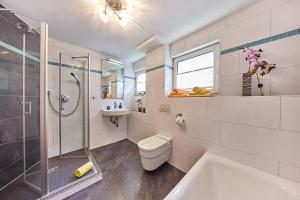 a bathroom with a shower and a toilet and a sink at Wohnung 22 - Auszeit - nur 5 Minuten vom Europa-Park in Kappel-Grafenhausen +9 photos