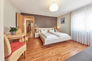 1 dormitorio con cama, mesa y escritorio en Wohnung 22 - Auszeit - nur 5 Minuten vom Europa-Park, en Kappel-Grafenhausen