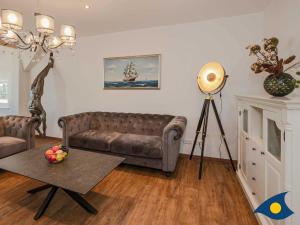 ein Wohnzimmer mit einem Sofa und einem Tisch in der Unterkunft Villa Ute Whg Conny in Bansin