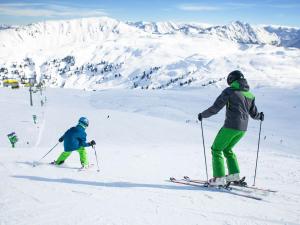 two people are skiing down a snow covered mountain at Holiday flat Sonnau, Bramberg am Wildkogel in Bramberg am Wildkogel