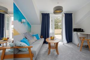 a living room with blue curtains and a couch at A.S.Apartamenty Bożena Bocian in Niechorze