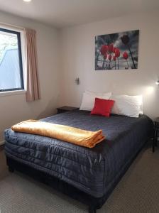 a bedroom with a bed with a blanket on it at All Seasons Holiday Park in Rotorua