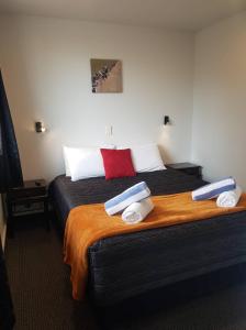 a bedroom with a large bed with towels on it at All Seasons Holiday Park in Rotorua