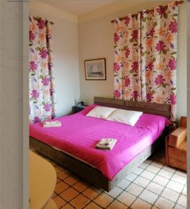a bedroom with a bed with pink sheets and curtains at Beit Wadih in Ghazīr