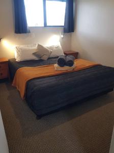a bedroom with a large bed with blue curtains at All Seasons Holiday Park in Rotorua