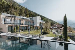 a house with a swimming pool next to a mountain at La Vista Nature Living in Tirolo