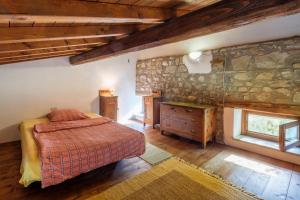 a bedroom with a bed and a stone wall at Stella Nord Podere Carbone in Grosseto