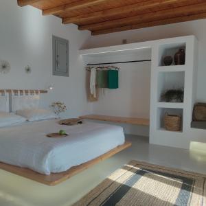 1 dormitorio con 1 cama blanca grande y techo de madera en Teal Rock Mykonos en Ano Mera