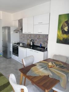 eine Küche mit einem Holztisch und weißen Schränken in der Unterkunft Derya'ca in Kaş + 17 Fotos