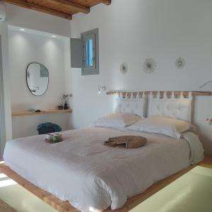a white bedroom with a large bed and a mirror at Teal Rock Mykonos in Ano Mera