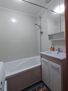 a bathroom with a white tub and a sink at Апартаменты 11 мкрн-3 in Aktobe