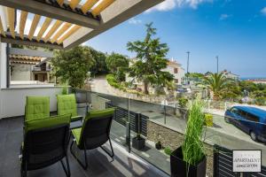 a balcony with green chairs and a view of a street at CroStar in Pješčana Uvala 