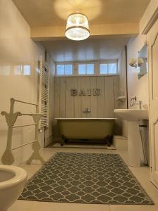 a bathroom with a bath tub and a sink at Chambres des Lunes in Aumagne