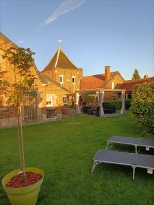 un patio con una mesa y un árbol en el patio en Au repos de la licorne, en Gommegnies