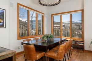 a dining room with a table and chairs and windows at Aspen Ridge 9 in Telluride