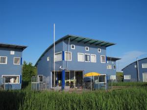 ein blaues Gebäude mit einem gelben Regenschirm davor in der Unterkunft Ferienhaus SEABIRD OOST150 in Oostmahorn