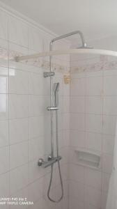 um chuveiro na casa de banho com azulejos brancos em Beach n Fun BBQ Fireplace em Saronida