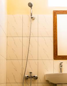 a shower in a bathroom with a sink and a mirror at Emerald Palm in Zanzibar City