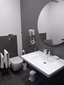 a bathroom with a sink and a toilet and a mirror at Granello di Sabbia in San Vito lo Capo