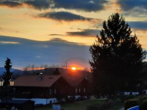 einen Sonnenuntergang mit aufgehender Sonne über einem Haus in der Unterkunft Fewo Bayerischer Wald, mit Wlan in Arrach