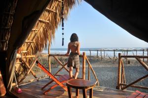 un hombre de pie en una cabaña mirando a la playa en Entremares, en Tonalá