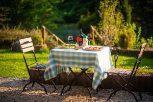 uma mesa com um prato de comida e copos de vinho em Landhotel Altes Zollhaus em Hermsdorf