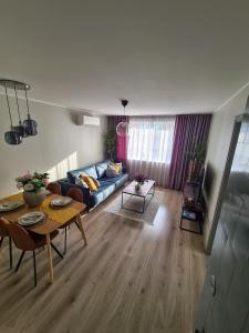 ein Wohnzimmer mit einem blauen Sofa und einem Tisch in der Unterkunft Hubane Olevi Apartment in Võru