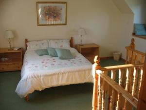 a bedroom with a bed with two pillows on it at Corehouse Farm Cottages - Dairy, Granary & Sawmill in Lanark
