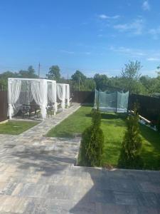 a garden with white curtains and a fence at Prykarpatska Villa in Morshin