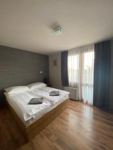 a bedroom with a large bed with white sheets at OwlCastle-Bagolyvár in Hajdúszoboszló