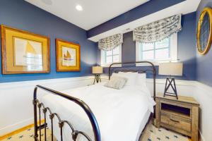 a bedroom with blue walls and a bed and a table at Sunset Island - Beachside Mews 1 & 2 in Ocean City +81 photos