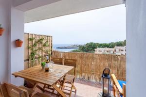 einen Holztisch auf einem Balkon mit Meerblick in der Unterkunft La Ola Beach House in Portocolom