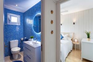 ein blau gefliestes Badezimmer mit Toilette und Waschbecken in der Unterkunft La Ola Beach House in Portocolom