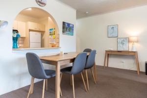 坦卡里的住宿－Seahorse 4，一间带木桌和蓝色椅子的用餐室