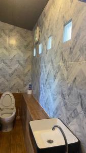 a bathroom with a sink and a toilet at ภูคำฮ้อมคลิฟฟ์ลอดจ์ แอนด์ โฮมสเตย์ Phu come home cliff Lodge & Homestay in Ban Phu Hi