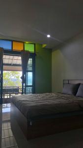 Un dormitorio con una cama y una ventana con colores arcoiris en ภูคำฮ้อมคลิฟฟ์ลอดจ์ แอนด์ โฮมสเตย์ Phu come home cliff Lodge & Homestay, en Ban Phu Hi