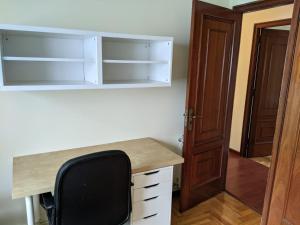 a desk with a black chair in a room at Piso 4 habitaciones calle Barcelona in Vigo