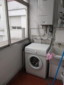 a laundry room with a washing machine and a window at Piso 4 habitaciones calle Barcelona in Vigo