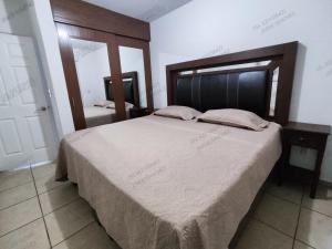 a bedroom with a large bed with a wooden headboard at Casa Villa Serena 8 in San Carlos