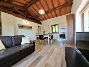- un salon avec un canapé noir et une table dans l'établissement Borgo Gatteraia, à Volterra