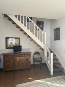 - un salon avec un escalier et une commode en bois dans l'établissement Apartamento Gaudi, à Comillas
