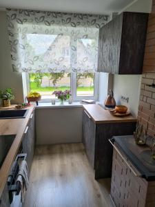 eine Küche mit einem großen Fenster und einer Arbeitsplatte in der Unterkunft Hubane Olevi Apartment in Võru