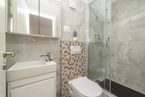 ein Bad mit einer Dusche, einem WC und einem Waschbecken in der Unterkunft Studio apartment JELI in Cavtat