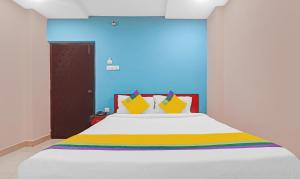 ハイデラバードにあるItsy Hotels Aflahのベッドルーム(大きな白いベッド、カラフルな枕付)