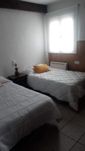 two beds in a hotel room with a window at Casa Flor in Arcas