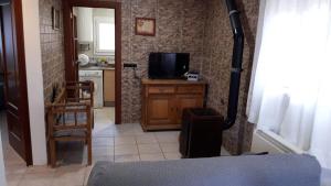 a living room with a television and a kitchen at Casa Flor in Arcas