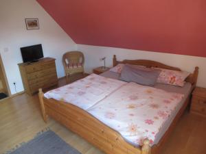 Schlafzimmer mit einem Bett, einem TV und einer Kommode in der Unterkunft Pension-Gästehaus Küblböck in Neualbenreuth